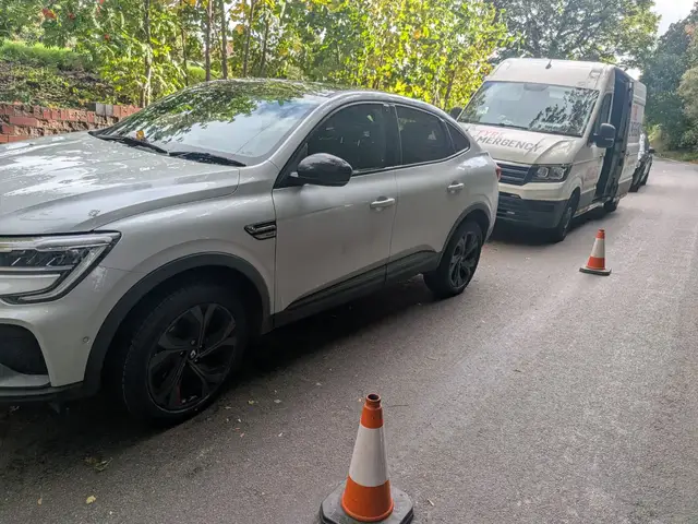 A white Renault at the kerb in Chesterfield with new tyres on both passenger-side wheels, cones out and the Tyre Emergency van parked in front