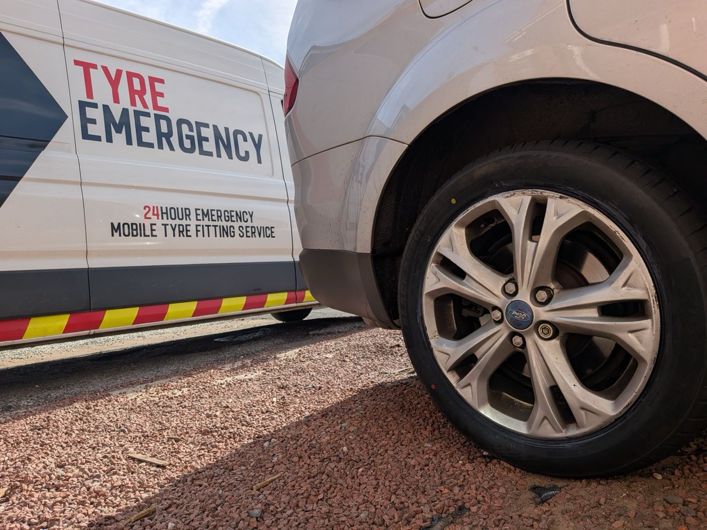 A Tyre Emergency van parked alongside a Ford with a flat rear tyre on a gravel driveway in Blidworth, near Mansfield