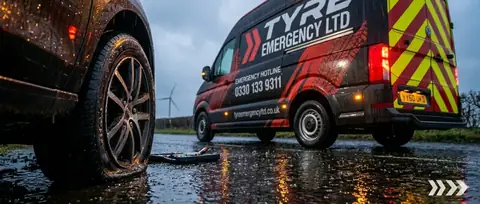 A tyre fitter checking the size on a tyre wall